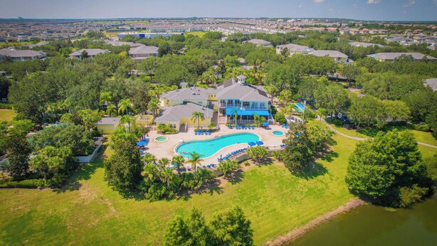 A large house with a swimming pool, surrounded by trees and a view of a residential area. - Go!#38 - BAHAMA BAY - Three Bedroom House, Sleeps 6 (Davenport)