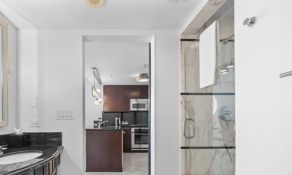 Une salle de bain moderne avec une douche en verre, un lavabo et un miroir.
