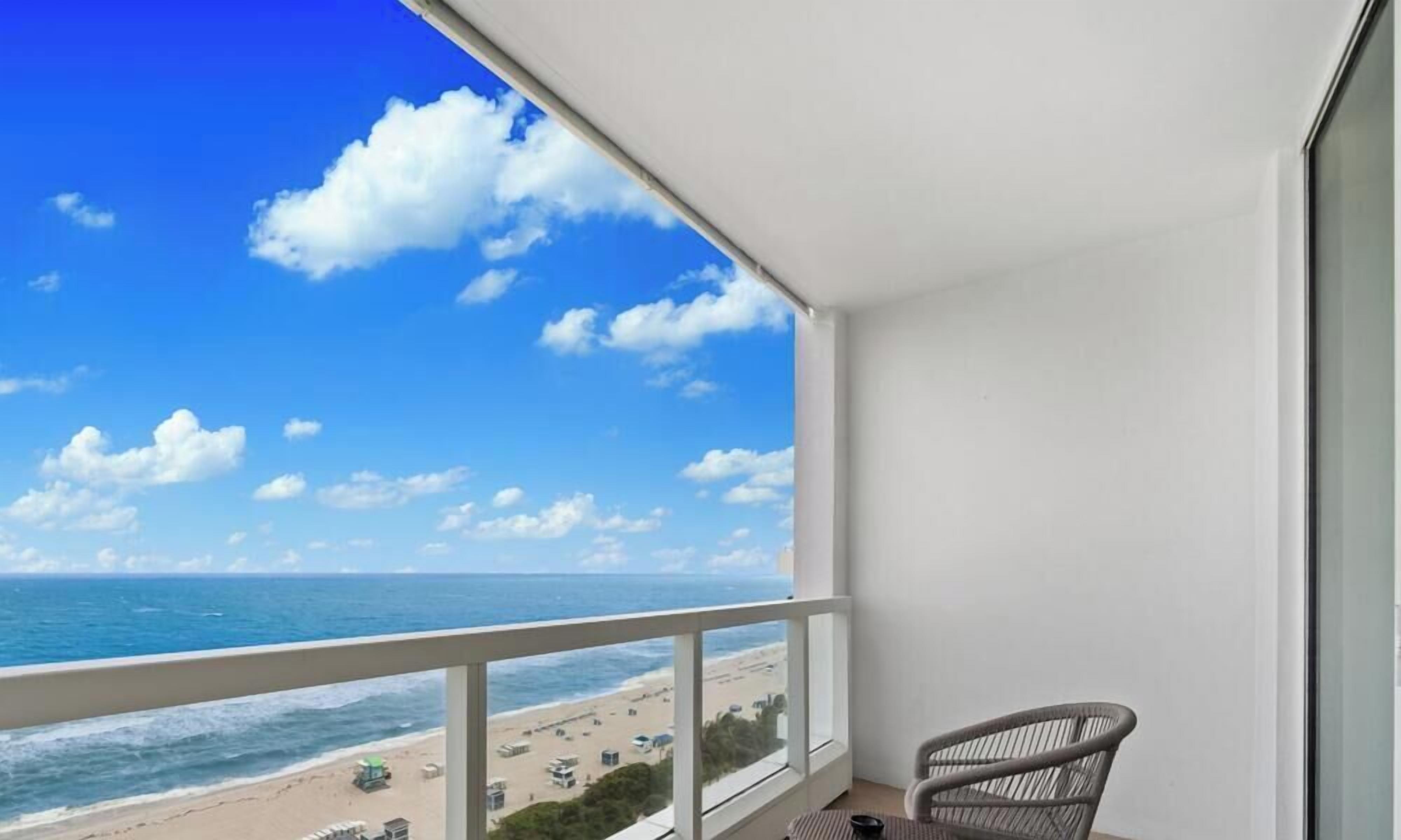 Uma varanda com vista para a praia e o oceano.