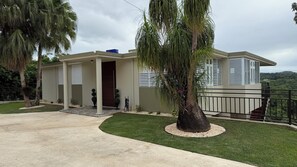 Une maison moderne dotée d’un porche abrit é, d’une allée et d’une pelouse bien entretenue.