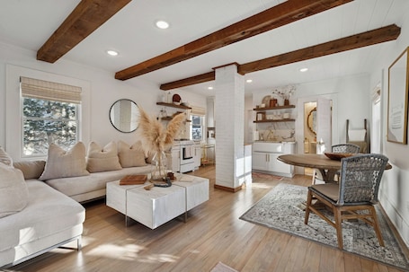 A spacious living area with a sofa, coffee table, and dining table.. Romantic Getaway- Luxury Little Bungalow for 2 in Linden Hills