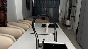 Una cocina moderna con una isla central, un lavamanos empotrado y una tabla de cortar de madera.
