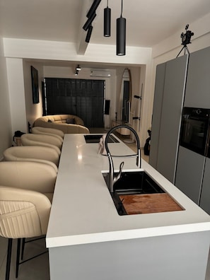A modern kitchen with a white countertop, a stainless steel sink, and a built-in oven. - B's House - Upscale 3-bed, 3-bath apartment for 6, downtown Pointe-à-Pitre (Pointe-à-Pitre)