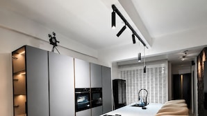 Una cocina moderna con una isla central, taburetes de bar y electrodomésticos integrados.