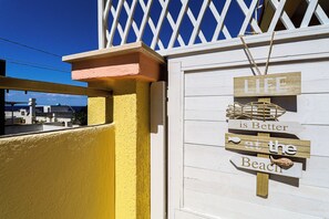 Ein Holzschild mit dem Schriftzug 'LIFE is Better at the Beach' und einer Fischverzierung.
