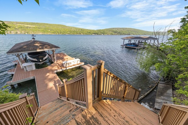 A wooden dock with a gazebo, a boat, and a small pier extending into the water.