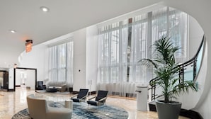 En rummelig lobby med marmorgulv, store vinduer og moderne siddepladser.
