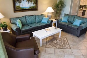 Ein Wohnzimmer mit zwei gemusterten Sofas, einem Couchtisch und einem Teppich mit Muster.
