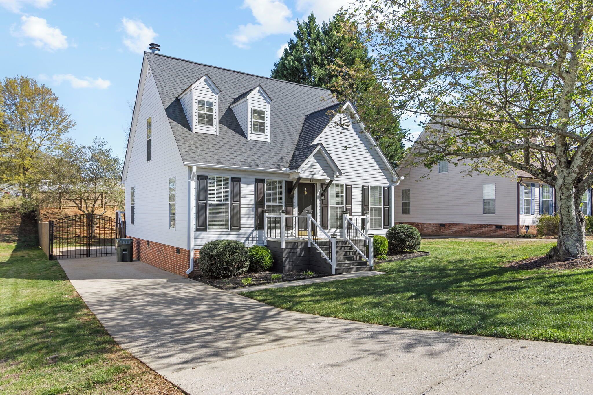 A two-story house with a front porch, a chimney, and a well-maintained lawn.
