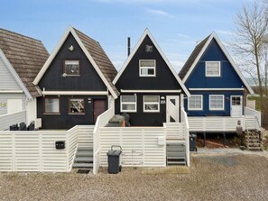 Tre huse i forskellige farver med enkel arkitektur.