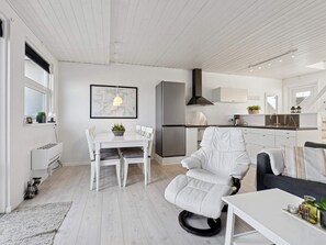 Et moderne køkken med spiseplads, en sofa og en stol.