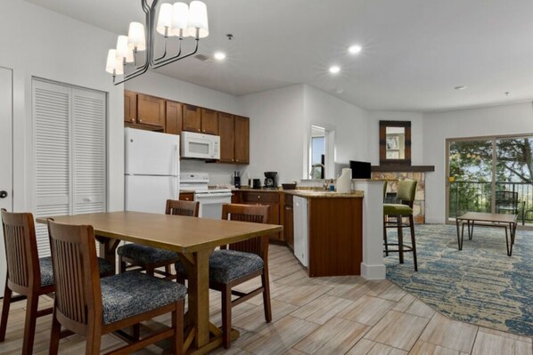Une cuisine moderne avec des meubles en bois, un îlot central et un coin repas avec des chaises.