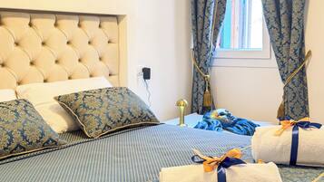 A neatly made bed with a tufted headboard, a patterned bedspread, and decorative pillows.