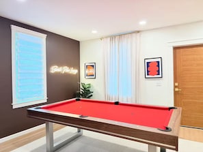 A pool table in a room with a neon sign, a framed picture, and a door. - Near Hersheypark, King Bed, Fire Pit, Pool Table, Fast WiFi, Walk to Food (Campbelltown)