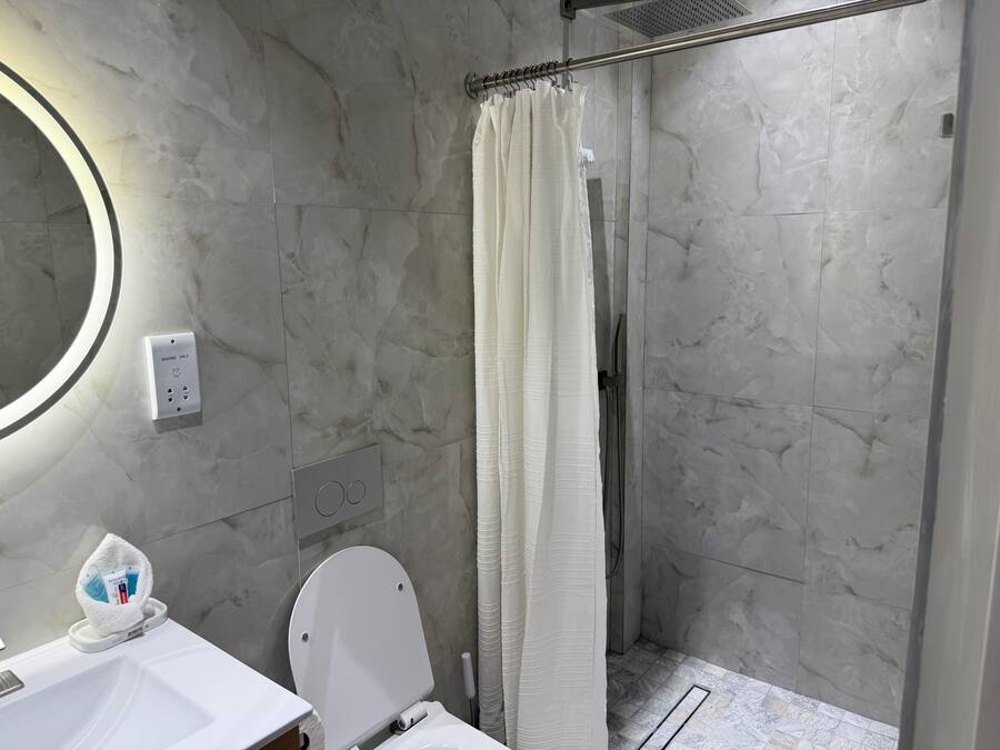 A bathroom with a shower, toilet, and sink.