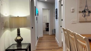 A hallway with a dining area featuring wooden flooring and white chairs. - A Vibrant Downtown Retreat for Groups, The Gallery (Halifax)