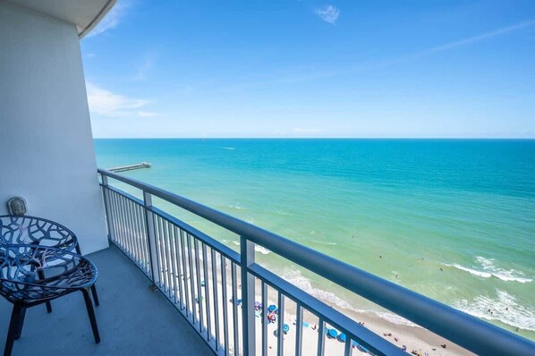 Ein Balkon mit Blick auf den Ozean und einen Steg.