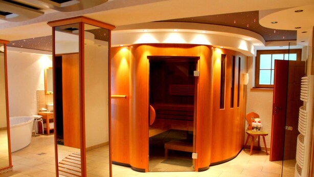 Un bagno moderno con un design curvo, un box doccia in vetro e una vasca da bagno a vista.