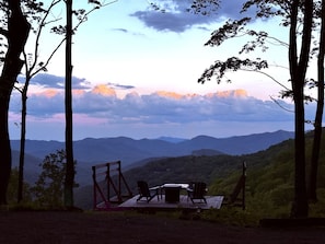 Eine Terrasse mit Tisch und Stühlen mit Blick auf eine gebirgige Landschaft.