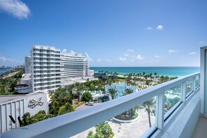 Um hotel moderno com vista para o oceano e área de piscina.