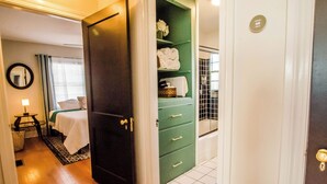 A hotel room with a bed, a green storage unit, and a bathroom with a tiled floor. - Bardstown Bourbon Royale, Just 1 block from Downtown Historic District (Bardstown)