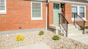 A brick house with a green door, white windows, and a concrete front porch with steps. - Bardstown Bourbon Royale, Just 1 block from Downtown Historic District (Bardstown)