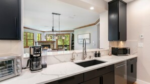 Una cucina moderna con forno integrato, macchina da caffè, forno a microonde e lavello.