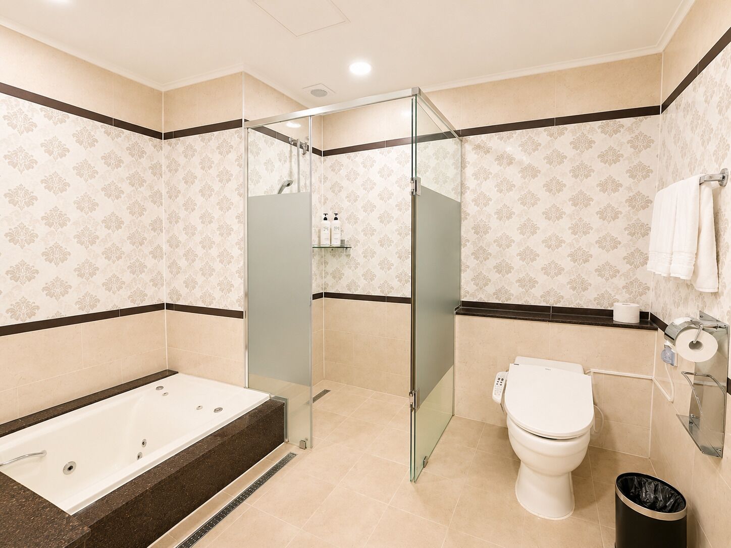 Et moderne badeværelse med bruseniche, badekar og toilet.