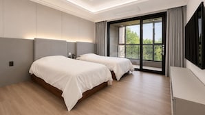 A modern hotel room with two beds, a large window, and a flat-screen TV. - Seosansoo Golf & Resort (Seosan)