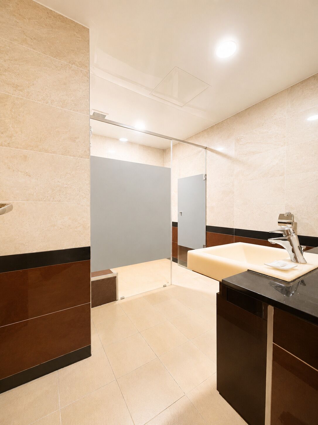 A modern bathroom with a glass partition, a sink, and a mirror.