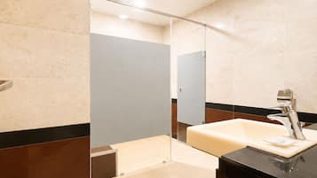 A modern bathroom with a glass partition, a sink, and a mirror.