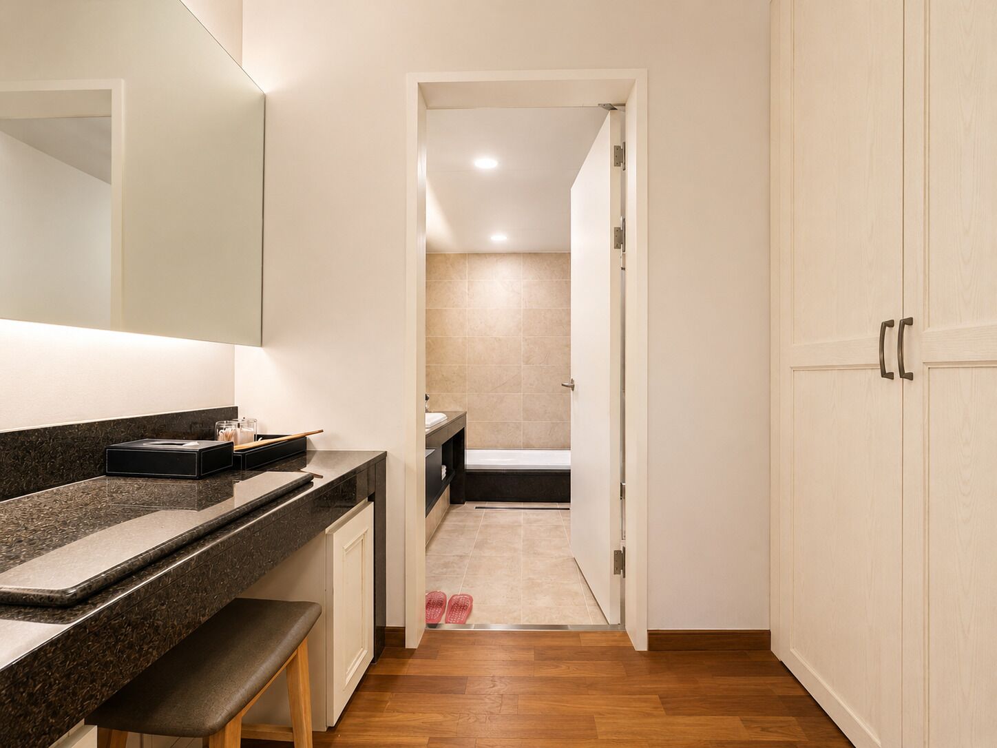 A modern bathroom with a shower, a bench, and a vanity with a mirror.
