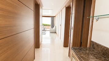 A hallway with wooden paneling, a marble countertop, and a row of black shoes.
