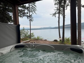 Un jacuzzi con vistas a un lago y montañas.