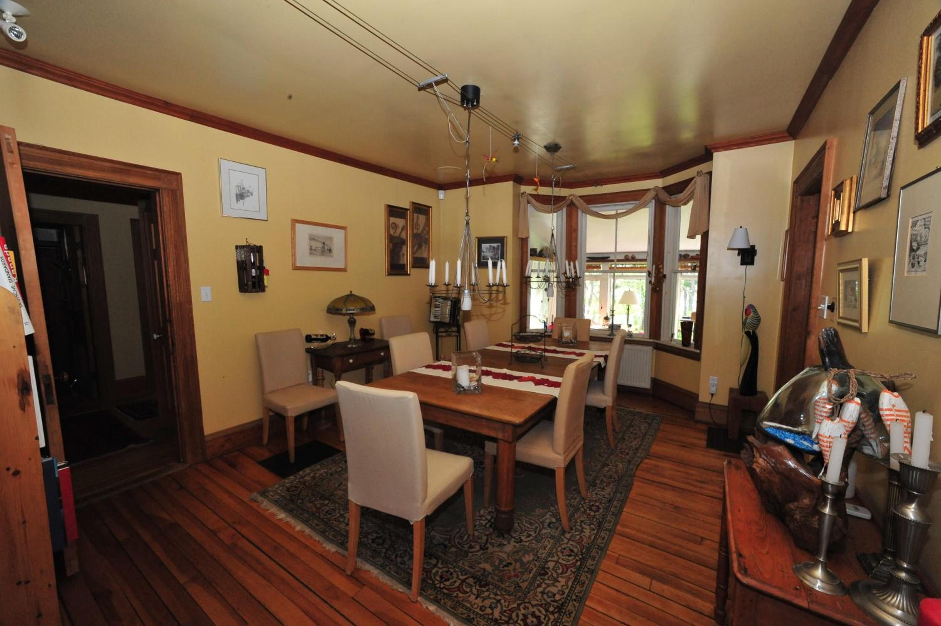 A dining area with a wooden table, chairs, and a chandelier.