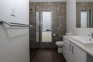 Une salle de bain moderne équipée d’une douche, de toilettes et d’un lavabo.