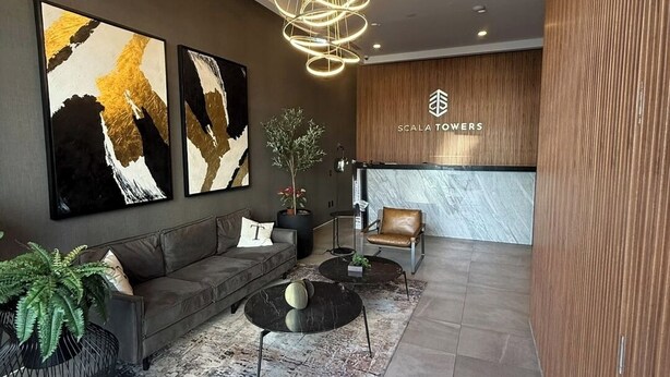 Eine moderne Lobby mit einer Couch, einem Couchtisch und einer dekorativen Leuchte.