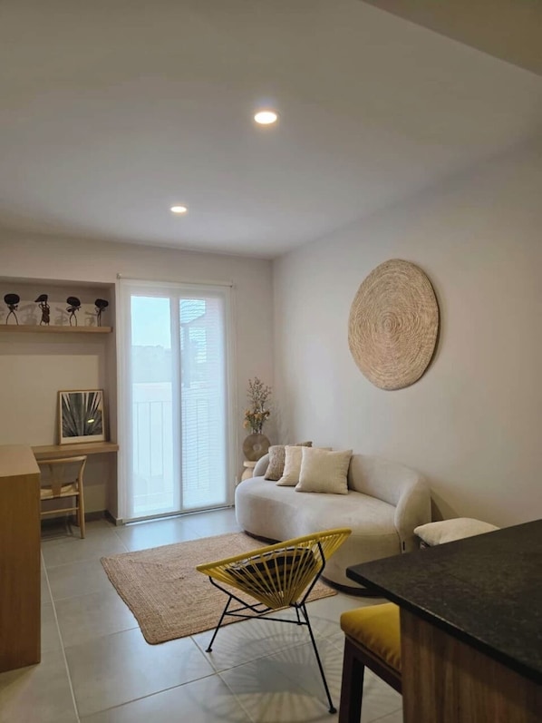 Un salon moderne avec un canapé, une table à manger et une chaise.