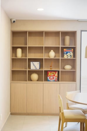 Une pièce avec une bibliothèque en bois, une table et des chaises.