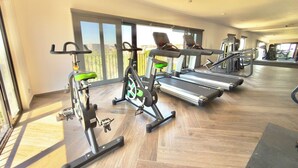 A gym with exercise equipment, large windows, and a wooden floor. - Mr. W : Cozy Urban Stay : Explore Guadalajara (Guadalajara)