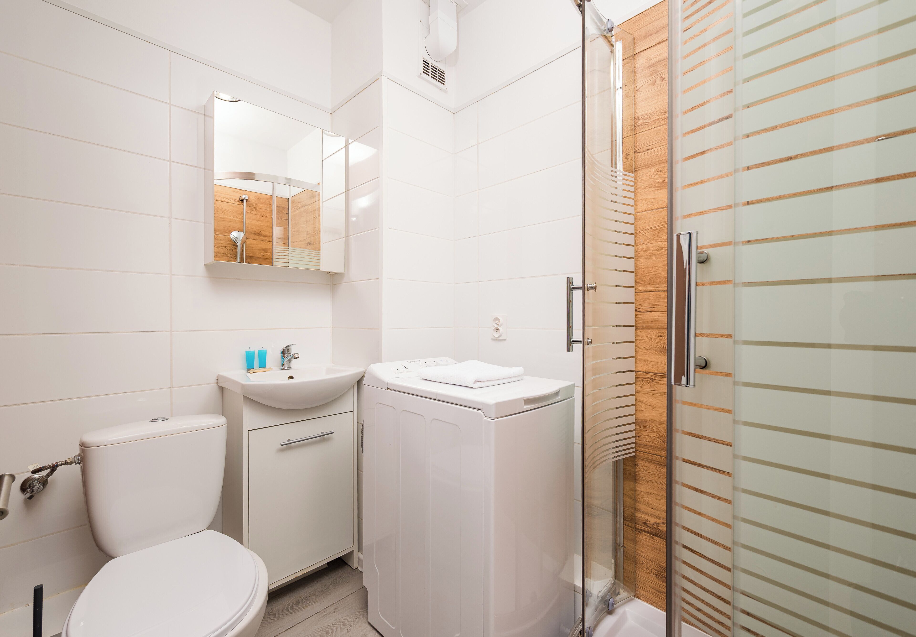 Un baño moderno con inodoro, lavamanos y lavadora.