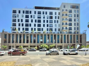 A multi-story building with a modern facade, several balconies, and a parking area with various vehicles. - Mr. W | Beautiful Apartment Close to Downtown GDL (Guadalajara)
