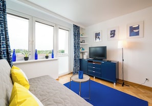 Een moderne hotelkamer met een bed, een televisie, een bureau en een raam met uitzicht.