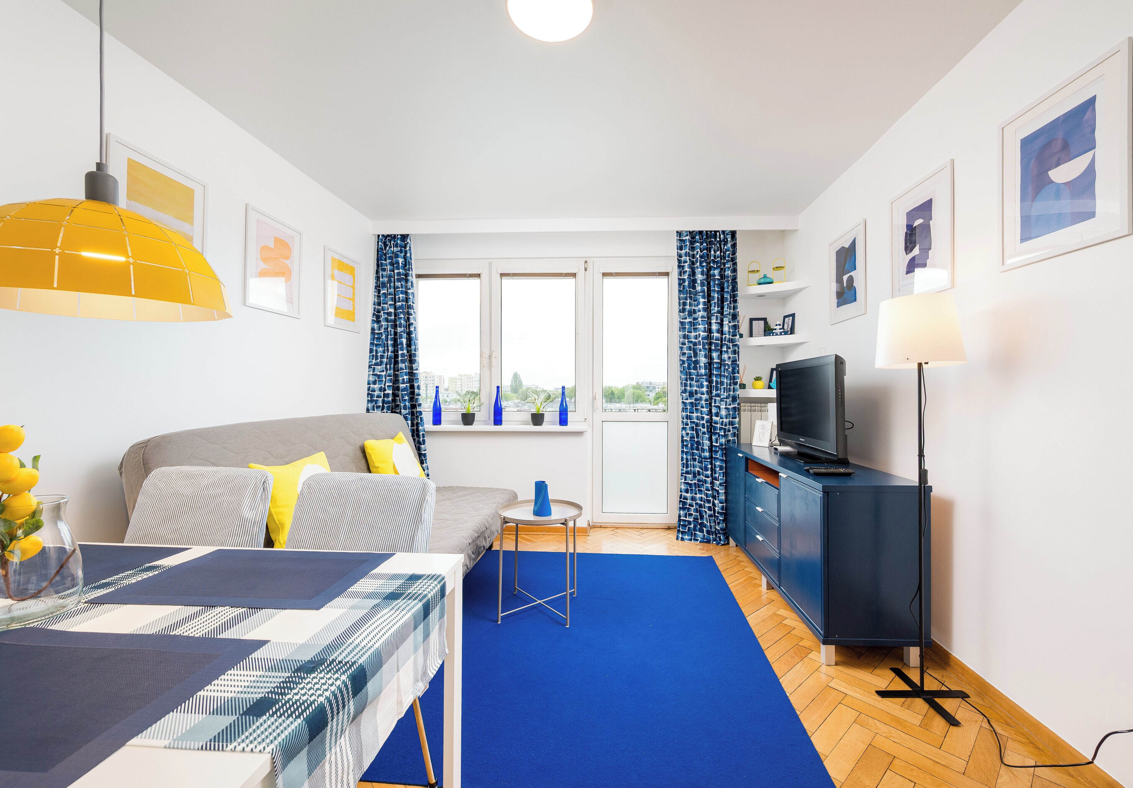 Une chambre moderne équipée d’un lit, d’une table à manger, d’un téléviseur et offrant une vue sur la ville.