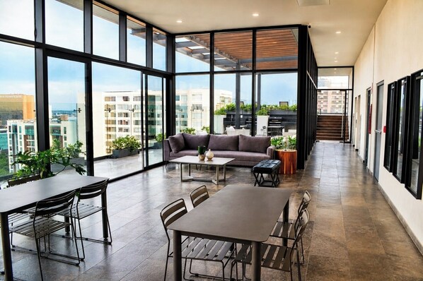 Ein modernes Interieur mit Essbereich, einer Couch und großen Fenstern mit Blick auf die Stadt.