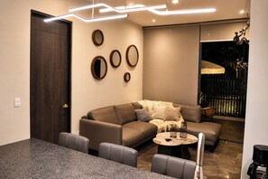 Ein modernes Wohnzimmer mit Sofa, Couchtisch und Sesseln.