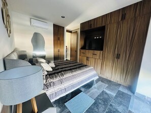 A modern bedroom with a bed, a TV, and a wardrobe. - Stylish 2BR Apartment at Torre Bermeo (Zapopan)