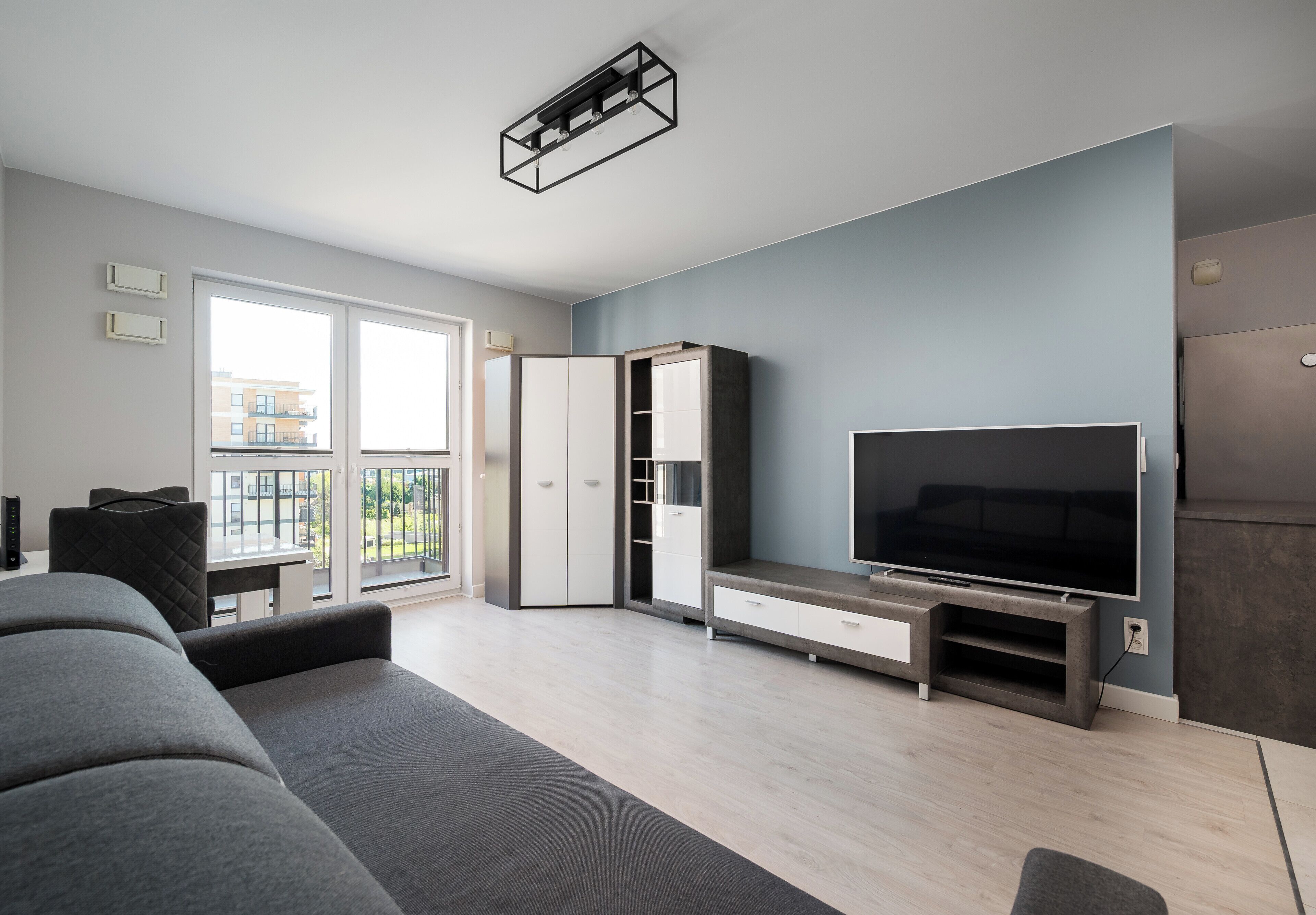 En moderne stue med sofa, fjernsyn og indbygget tv-møbel.