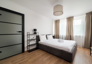 Ein modernes Schlafzimmer mit Bett, Schrank, Schreibtisch und Lampe.