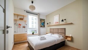 Ein modernes Schlafzimmer mit einem großen Bett, Holzboden, eingebautem Kleiderschrank und einem Fenster mit Blick.